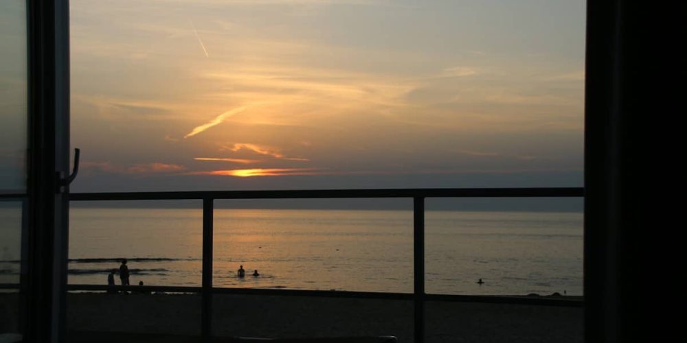Blick aus dem Ferienhaus auf den Sonnenuntergang am Strand