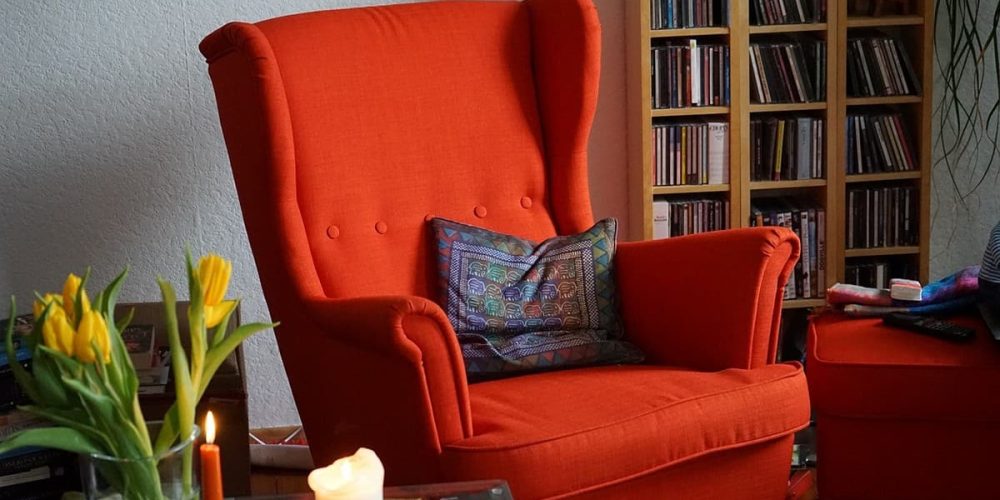 Roter Sessel im Wohnzimmer vor Buecherregal
